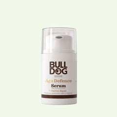 A bottle of Age Defence Serum with natural origin ingredients to target fine lines and wrinkles, shown with a white pump dispenser and clear cap against a pale green background.