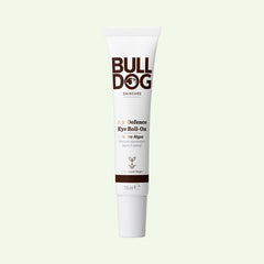A tube of Age Defence Eye Roll-On for mens skincare, featuring marine algae to reduce signs of aging, stands upright on a light background. The white packaging displays brown and gold text.